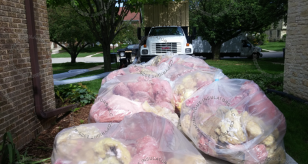 Bags of fiberglass batting removed from an attic.